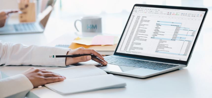 A person analyzes a spreadsheet on a laptop, representing the use of data-driven insights in clinical reviews for Stop Loss insurance.