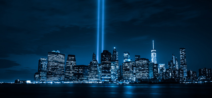 Manhattan skyline at night post 9/11 featuring two spotlights where twin towers stood.