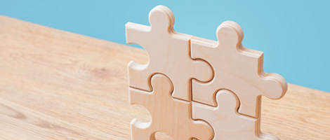 Four wooden puzzle pieces fit together, representing the clarity and completeness of forms and guides.
