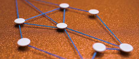 A blue string connects white pins on an orange surface, showing the interconnectedness of tools and resources.
