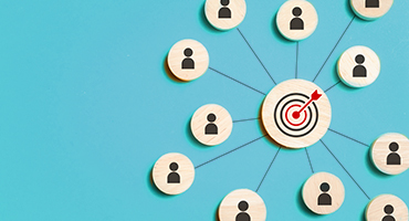 Wooden circles with person icons connect to a bullseye, showing how dedicated teams aim for excellent client service.