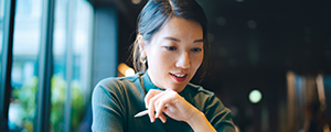 A young adult looks attentively at a tablet, representing how HMConnects delivers opportunities to control claim costs.